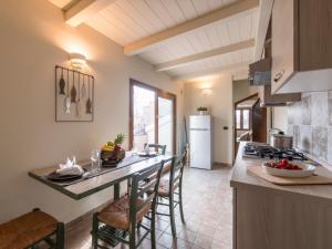 加比切马莱Appartamenti Villa Tonni的厨房配有带椅子和炉灶的柜台