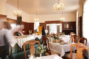 哥廷根汉诺威斯塔德特酒店的用餐室配有带白色桌布的桌子