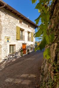 特雷莫西内Borgo Cantagallo Casa Ofelia的街上一座带黄色百叶窗的石头建筑