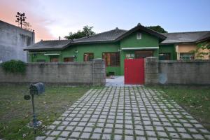 高雄眷村恋影民宿的一座带红色门和栅栏的绿色房子