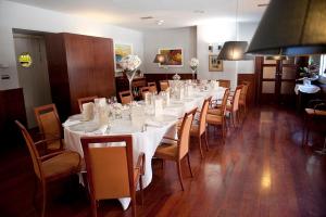 曼列乌Hotel Torres Manlleu的长长的用餐室配有长桌子和椅子