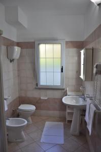 梵蒂冈角Rosy Hotel Residence的一间带两个盥洗盆、卫生间和窗户的浴室