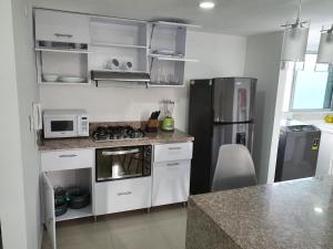 库库塔Excelente Apartamento Completo, en la mejor zona的厨房配有炉灶和冰箱。