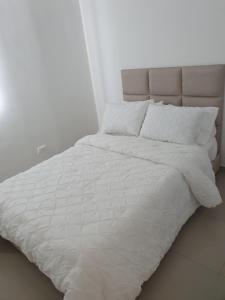 库库塔Excelente Apartamento Completo, en la mejor zona的白色的床、白色床单和枕头