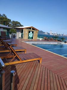 巴拉奈里奥-坎布里乌Flat Prédio Frente MAR的游泳池旁带木凳的甲板
