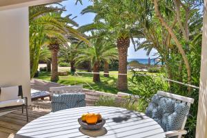 米乔尔海滩Talaya Formentera的一个带桌椅和棕榈树的庭院