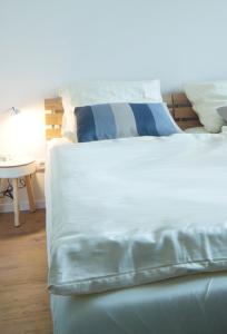 奎克博恩Q55 - Quartier 55的一张白色的床,配有蓝色和白色的床单和桌子