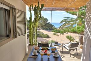 米乔尔海滩Talaya Formentera的阳台上的桌子上摆放着食品和饮料,可欣赏到海景