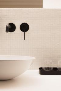 Saint-SauveurVertes Feuilles的浴室设有白色瓷砖墙和水槽