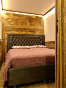 布勒伊-切尔维尼亚Central Apart Chalet的一间卧室配有一张带木制床头板的床