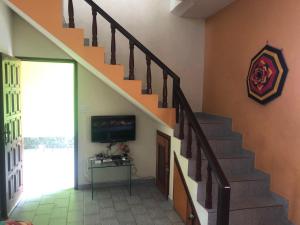 皮乌马De Angelis - Casa de praia em Piuma com WI-FI的一间带楼梯和电视的客厅
