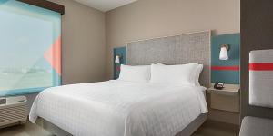 沃伦avid hotels - Detroit - Warren, an IHG Hotel的卧室配有白色的床和窗户。