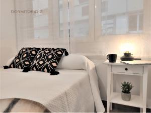 桑坦德Suite Haus Vargas的一张带黑白枕头和桌子的床