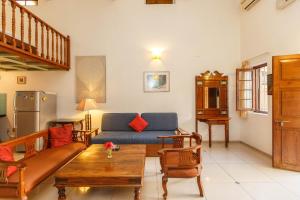 班加罗尔卡萨小屋酒店的客厅配有沙发和桌子
