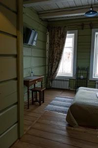 伊尔库茨克Бутик-Отель "Доходный Дом Листратовой"的一间卧室配有一张床、一张书桌和一个窗户。
