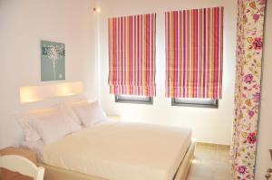 克里奥斯Kleopatra Villas - Seaside Suites的卧室配有白色的床和2扇窗户。