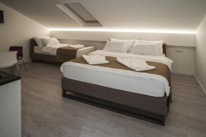 贝尔格莱德萨瓦马拉别墅公寓的酒店客房带两张床和一张床罩