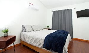华雷斯城Casa Antara的一间卧室设有一张床和一个带电视的窗户。