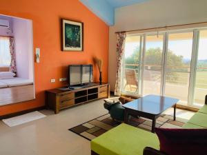 恒春古城垦丁卡米克特色民宿的客厅设有橙色墙壁和电视