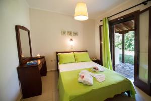 雷夫卡达镇Villagio的一间卧室配有绿床和毛巾