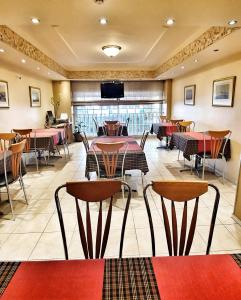 比雷埃夫斯努法拉酒店的餐厅设有桌椅和平面电视。