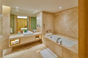 孟买孟买国际机场假日酒店的带浴缸、水槽和镜子的浴室