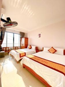 Sơn ÐìnhGia Hiếu Hotel的酒店客房设有两张床和大窗户。