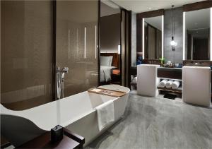 南京南京长江之舟华邑酒店的带浴缸的浴室和卧室