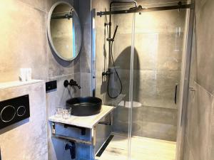 奈梅亨Hotel de Prince的一间带水槽和玻璃淋浴的浴室