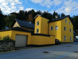 蓬高地区施瓦察赫Appartement Tauernlife的街上的一座黄色房子,有车库