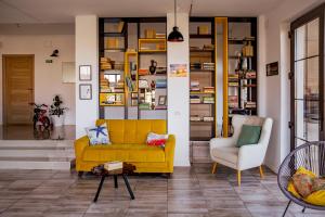 旧瓦马Happy In Vama Veche的客厅配有黄色的沙发和椅子