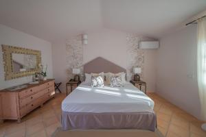 阿尔扎凯纳Hotel Borgo Smeraldo的卧室配有白色大床和梳妆台