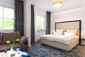 不莱梅库泽腾酒店的一间卧室配有一张床和一张沙发