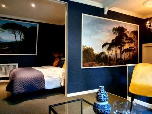 KlimmenBoutique Hotel Villa de Proosdij的卧室配有一张床,墙上挂有绘画作品