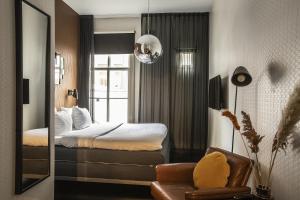 阿姆斯特丹V弗雷德里克斯酒店的酒店客房,配有床和镜子