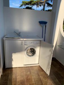 普尔萨诺appartamento VENTO的洗衣机上方设有水槽