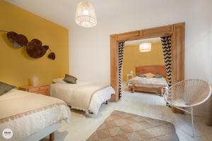 阿尔比卡罗琳别墅 - 尚布勒酒店的一间卧室配有两张床和镜子