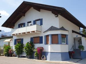 罗伊特Anita's Ferienwohnung nahe Neuschwanstein的白色的房子设有蓝色的窗户和阳台