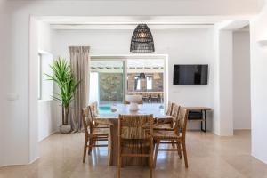 法蒂亚Mykonos AG Villas in Ftelia Beach的一间带桌椅的用餐室