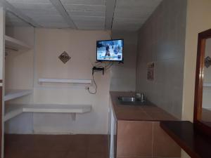 贾拉普La Casa Azul Hostal y Pension - Coatepec的一间带水槽的浴室和墙上的电视