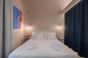 诺托Sikelia Suites的卧室配有一张带两个枕头的大白色床