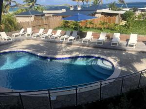 东方湾Orient Beach Hotel的一个带椅子和遮阳伞的游泳池