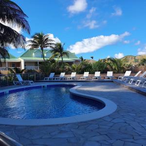 东方湾Orient Beach Hotel的一个带躺椅的游泳池,棕榈树