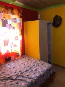 Laguna VerdeCabaña Quiahuiztlán Playa Villa Rica的一间卧室设有一张床和色彩缤纷的墙壁