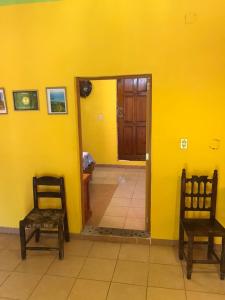 Laguna VerdeCabaña Quiahuiztlán Playa Villa Rica的一间设有两把椅子和黄色墙壁的房间