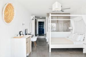 MakriliesSamothraki Beach Boutique Hotel的白色卧室配有双层床和书桌