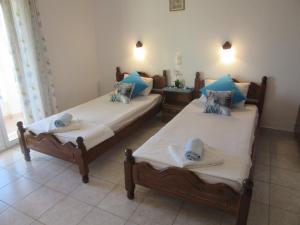 ArgyrádesAris Paschalia Studios的配有蓝色枕头的客房内的两张床