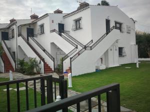 英格兰海滩Apartamentos Corona Playa的白色的建筑,旁边设有楼梯