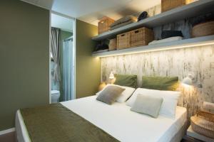 沃德年Papafigo Camping的卧室配有白色的床和带架子的墙壁