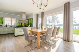 滨湖克拉科Luxus-See-Domizil mit Sauna, Kamin und Boot-130 qm für 6 Personen的厨房以及带木桌和椅子的用餐室。